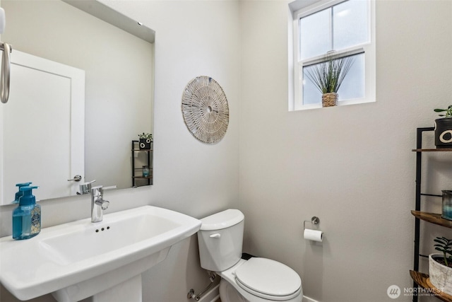 half bath featuring toilet and a sink