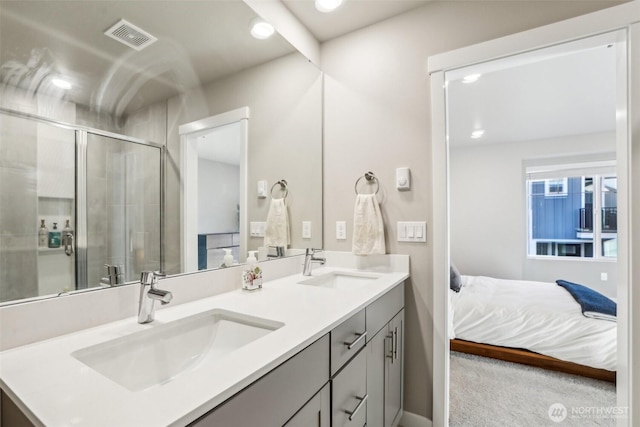 ensuite bathroom with connected bathroom, a sink, visible vents, a shower stall, and double vanity