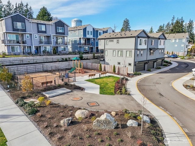 view of home's community featuring a residential view, fence, and a playground