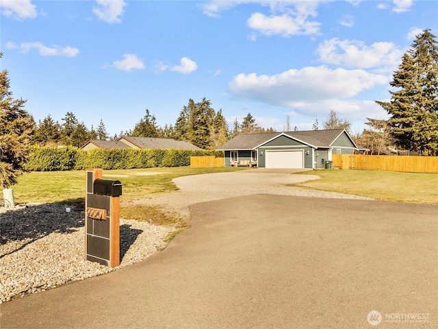 ranch-style home with driveway, a front lawn, an attached garage, and fence