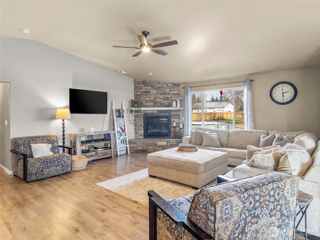 living area featuring visible vents, a ceiling fan, lofted ceiling, wood finished floors, and a fireplace