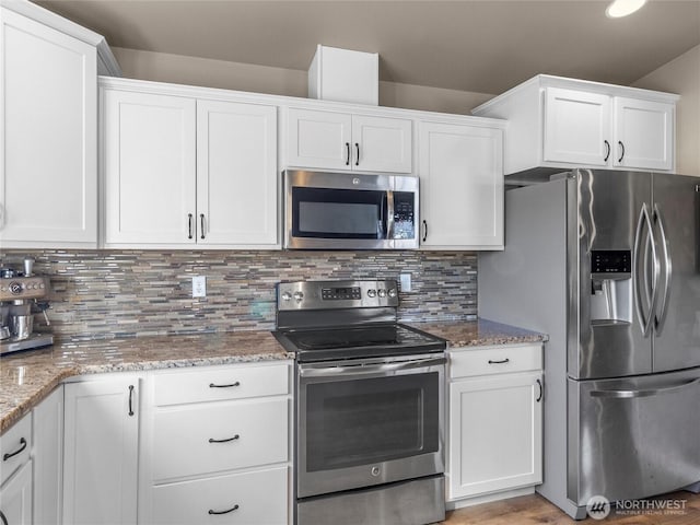 kitchen with stainless steel appliances, light stone countertops, white cabinetry, and tasteful backsplash