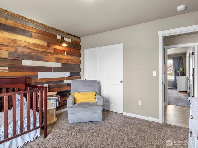 carpeted bedroom featuring baseboards, a closet, and wooden walls