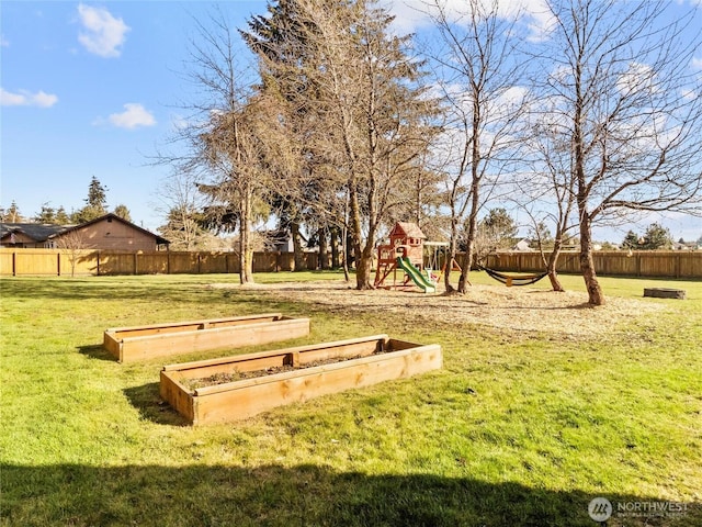 view of property's community featuring a garden, a fenced backyard, a playground, and a lawn