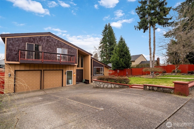 view of front of property with driveway, an attached garage, fence, a front lawn, and board and batten siding