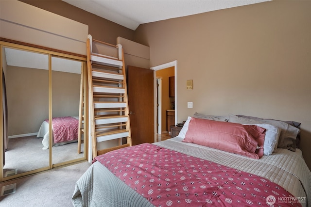 bedroom with lofted ceiling, carpet, visible vents, and a closet