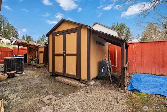 view of shed with a fenced backyard and central air condition unit