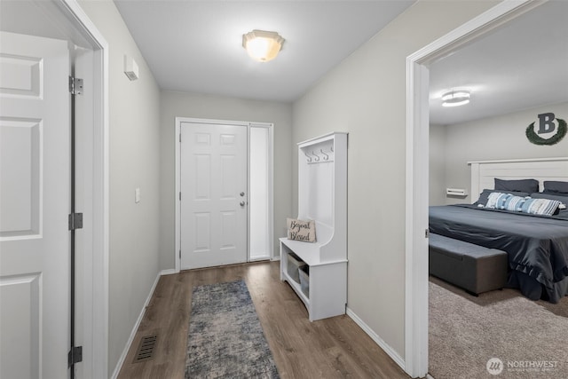 interior space featuring visible vents, baseboards, and wood finished floors