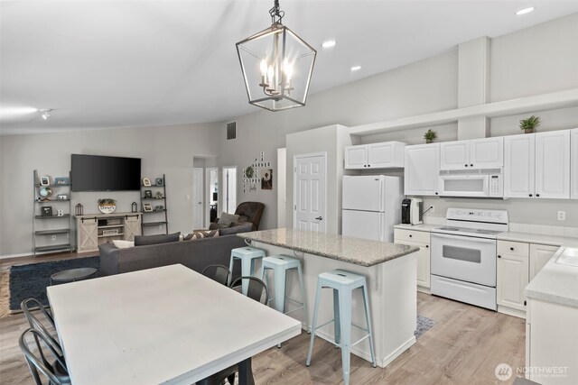 kitchen featuring white appliances, white cabinets, light wood-style floors, and vaulted ceiling