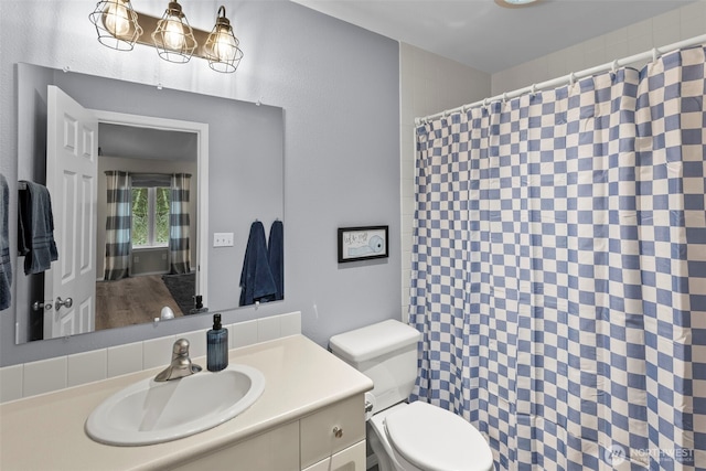 full bathroom featuring toilet, vanity, and a shower with curtain