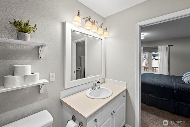 bathroom with toilet, ensuite bath, and vanity