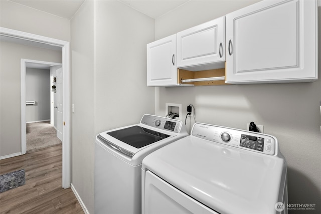 washroom with washer and dryer, wood finished floors, cabinet space, and baseboards