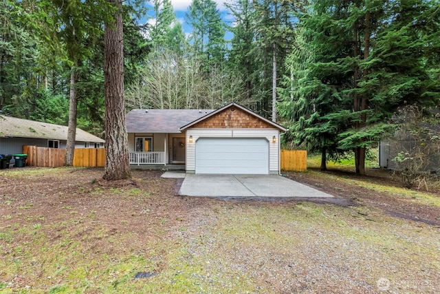 single story home featuring covered porch, driveway, a garage, and fence