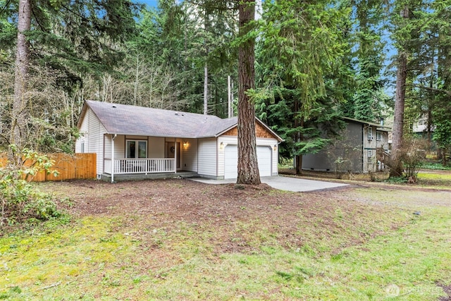 ranch-style home with a porch, an attached garage, fence, and concrete driveway