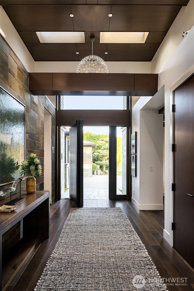 entryway featuring baseboards and dark wood-style flooring