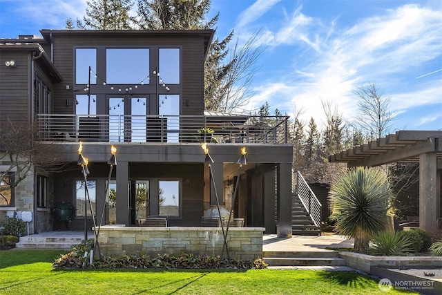 back of property featuring a yard, stairs, and a balcony