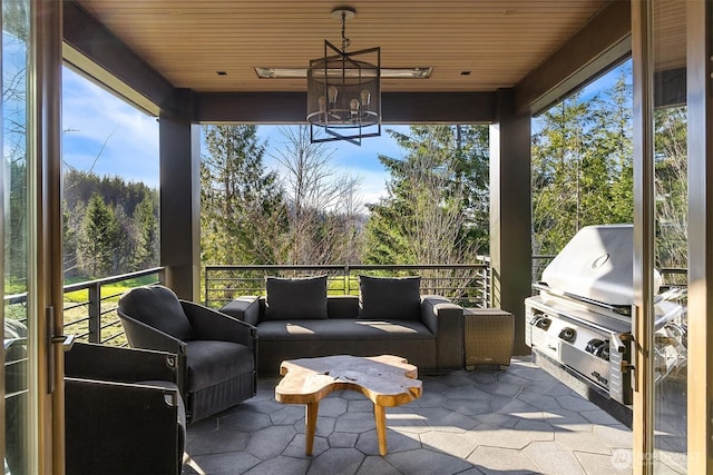 sunroom featuring wood ceiling and a chandelier