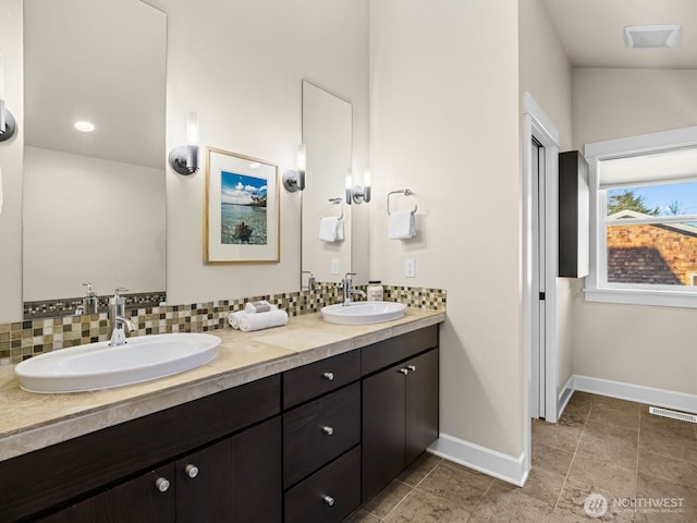 full bath with baseboards, backsplash, and a sink