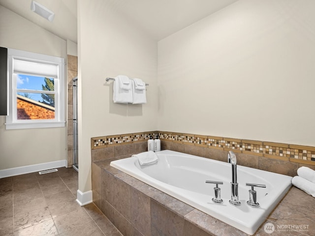 full bath featuring a stall shower, a garden tub, visible vents, and baseboards