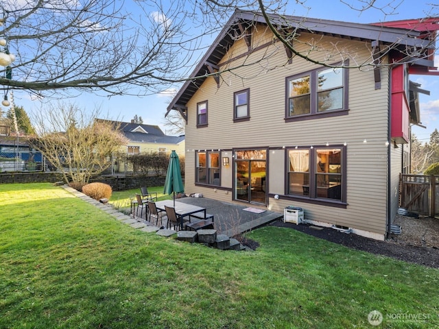 rear view of house featuring a patio area, a yard, and fence