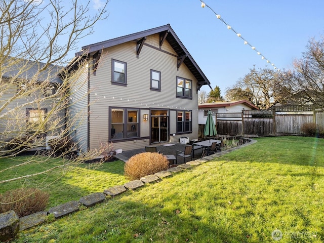 back of property with a patio, a lawn, and fence