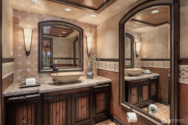 bathroom with a wainscoted wall, tile walls, and vanity