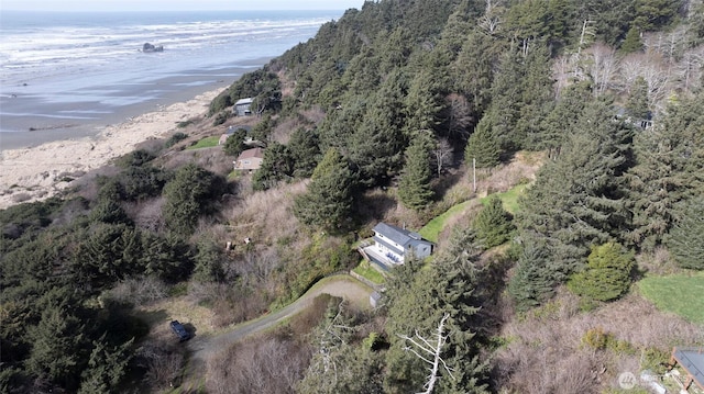 bird's eye view with a water view, a wooded view, and a view of the beach