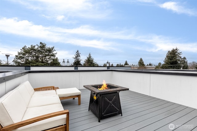 wooden terrace with an outdoor living space with a fire pit