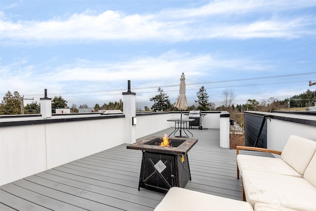 deck featuring an outdoor living space with a fire pit and area for grilling