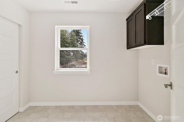 washroom with cabinet space, hookup for a washing machine, baseboards, and light floors