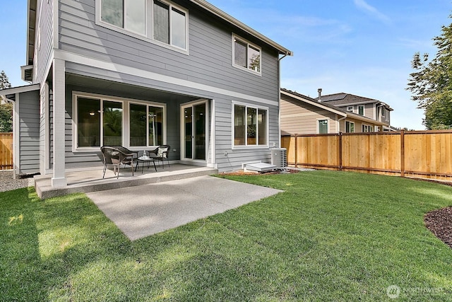 rear view of house with a patio area, a fenced backyard, and a lawn