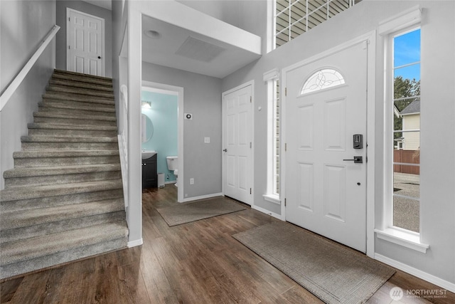 entryway featuring baseboards, stairway, and dark wood-type flooring