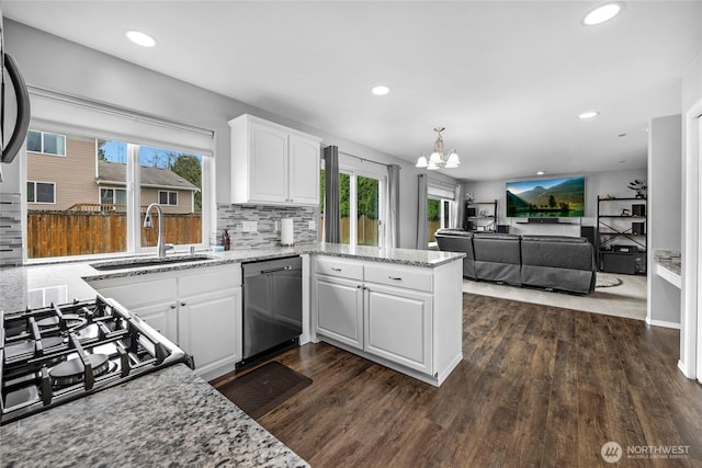 kitchen with dark wood-style flooring, a peninsula, stainless steel dishwasher, white cabinetry, and a sink