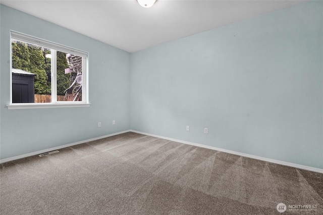 spare room with carpet, visible vents, and baseboards