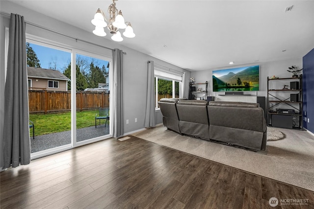 living room with an inviting chandelier, light wood-style flooring, and baseboards