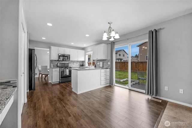 kitchen featuring stainless steel appliances, visible vents, white cabinetry, backsplash, and dark wood finished floors