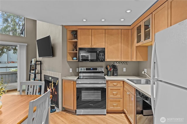 kitchen with dishwasher, freestanding refrigerator, light countertops, stainless steel range with electric stovetop, and black microwave