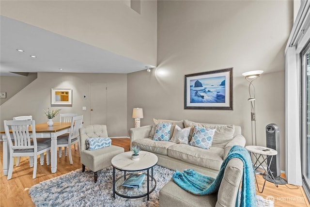 living area with recessed lighting, light wood-type flooring, and baseboards