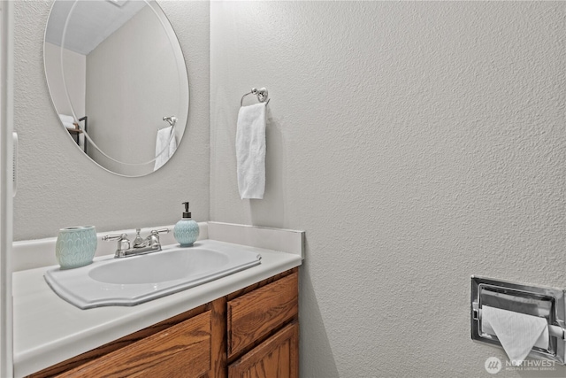 bathroom featuring a textured wall and vanity