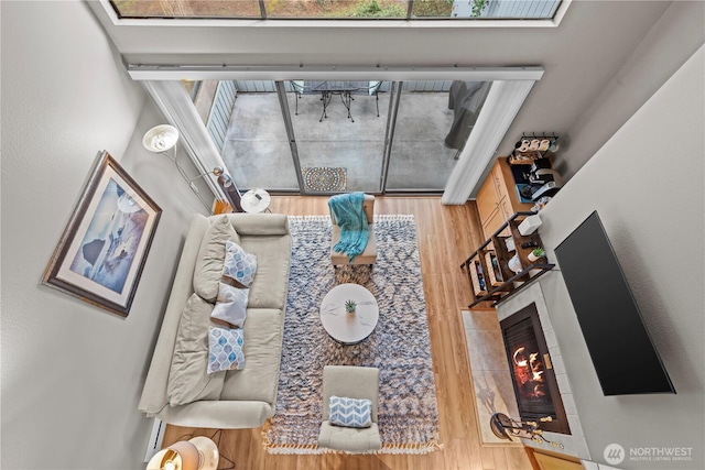 living room with a tiled fireplace and wood finished floors