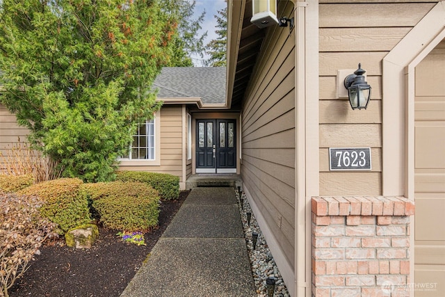 entrance to property with roof with shingles