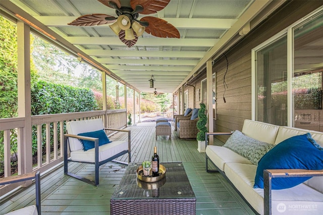 wooden deck with outdoor lounge area and ceiling fan