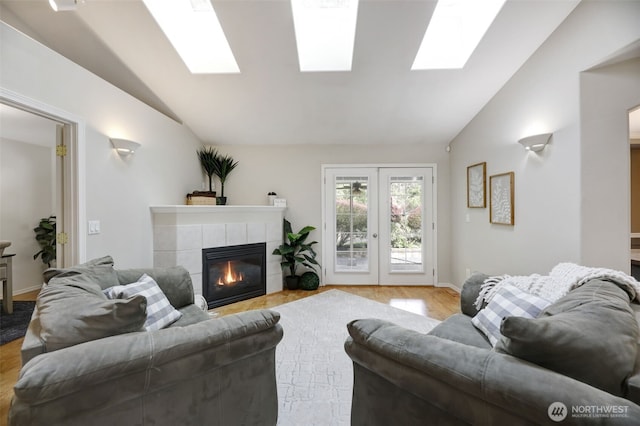 living area with light wood-type flooring, french doors, lofted ceiling, and a fireplace