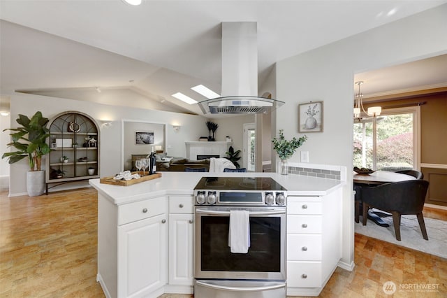 kitchen featuring light countertops, vaulted ceiling, island exhaust hood, electric stove, and white cabinetry