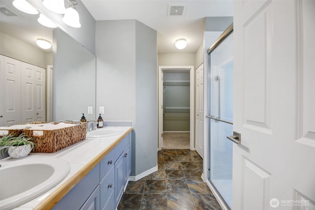 full bathroom with double vanity, visible vents, and a sink