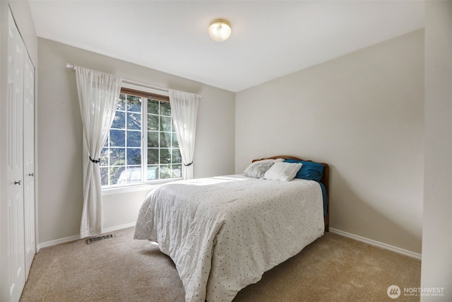 bedroom with carpet flooring, baseboards, visible vents, and a closet