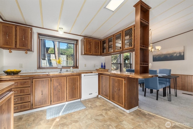 kitchen with brown cabinets, white dishwasher, and a sink