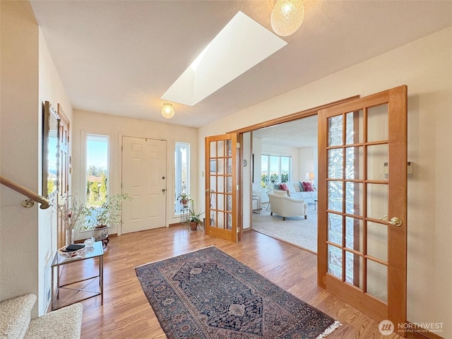 entryway featuring a skylight, wood finished floors, and french doors