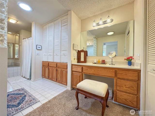 full bathroom with a shower with curtain, a closet, a textured ceiling, vanity, and tile patterned flooring