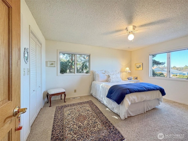 bedroom with a ceiling fan, light colored carpet, and baseboards